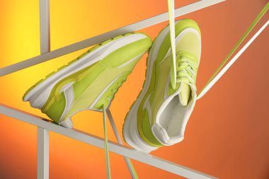 Renk arkaplanına karşı spor ayakkabılarının şık sunumu