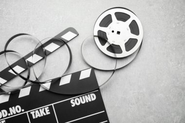 Gri desenli masa üzerinde film makarası ve film makarası, düz konum