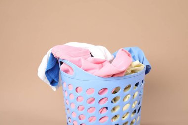 Bej arka planda içi çamaşır dolu plastik sepet.