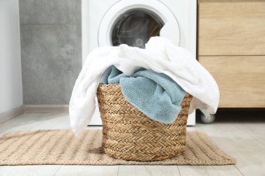 Banyoda yerde çamaşır dolu bir sepet.