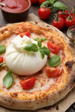 Burrata peynirli, fesleğenli ve domatesli lezzetli pizza, yakın plan.