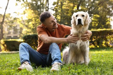 Gülümseyen adam ve tatlı Golden Retriever köpeği bahar günü