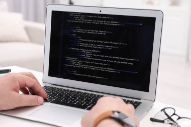 Ofisteki beyaz masada dizüstü bilgisayarla çalışan programcı, kapat