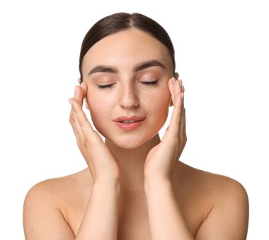 Güzel genç bir kadın beyaz arka planda yüz masajı yapıyor.