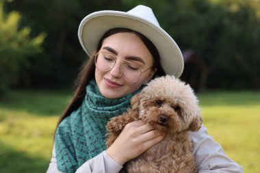 Sonbahar parkında sevimli köpekli bir kadın.