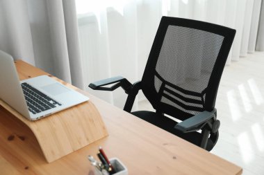 Siyah sandalye, dizüstü bilgisayar ve masa