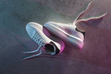 Neon ışıklarda gri desenli arka plana karşı şık bir çift spor ayakkabı.