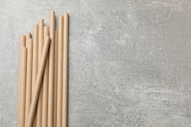 Gri desenli masada bambu pipetleri içmek, üst manzara. Metin için boşluk