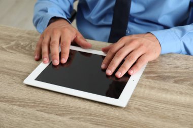 İşadamı ahşap masada tablet kullanıyor, yakın plan. Modern teknoloji