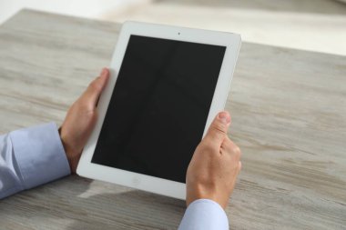 İşadamı ahşap masada tablet kullanıyor, yakın plan. Modern teknoloji