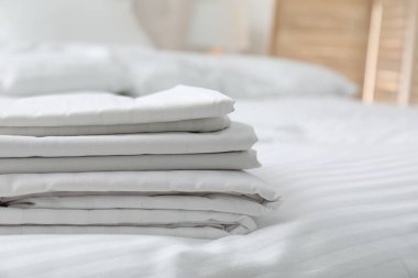 İçerideki yatağa temiz çarşaf yığını, yakın plan.