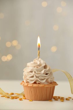 Bulanık ışıklara karşı yanan mumlu doğum günü pastası.