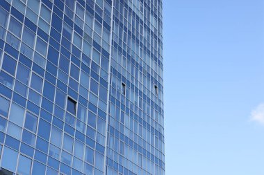 Mavi gökyüzüne karşı birçok penceresi olan modern binanın dışı. Metin için boşluk