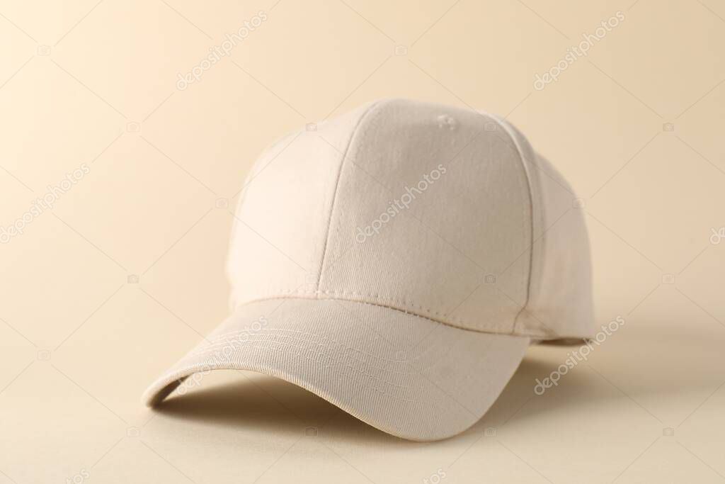 Stylish baseball cap on beige background, closeup. Mockup for design