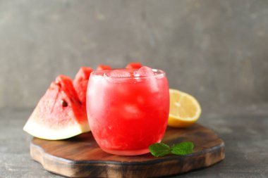 Bardakta lezzetli karpuz, taze meyve ve gri masada nane, yakın plan.