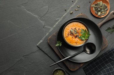 Koyu dokulu masada servis edilen baharatlı balkabağı çorbası. Metin için boşluk