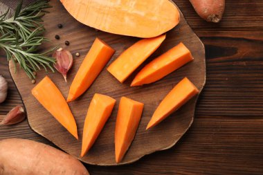 Taze patates, biberiye, sarımsak ve ahşap masada biber karışımı.