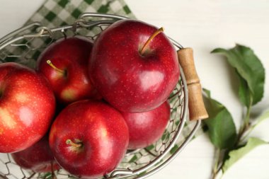 Taze olgun kırmızı elmalar sepetin içinde beyaz masada, yakın plan