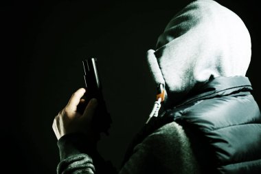 Siyah arka planda silahı olan tehlikeli bir suçlu. Silahlı soygun.
