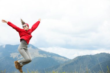 Dağlarda zıplayan mutlu, genç yürüyüşçü, alçak açılı. Metin için boşluk
