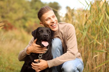 Gülümseyen adam ve sevimli köpek sonbahar günü açık havada