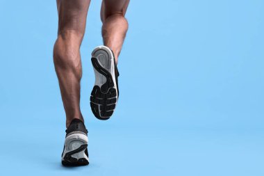 Açık mavi arka planda çalışan adam, yakın plan