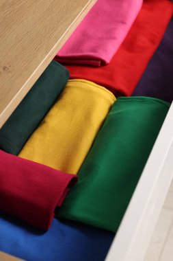 Farklı katlanmış elbiseli çekmeceler, yakın plan.