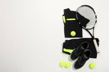 Tenis raketi, toplar ve beyaz arka planda spor giyim, düz yatış. Metin için boşluk