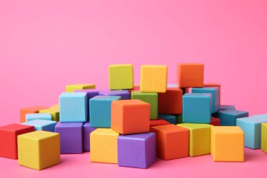 Pembe arka planda bir sürü ahşap renkli küp