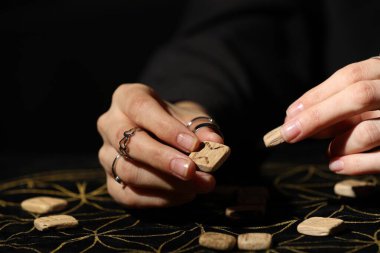 Kehanet minderinde tahta rünleri olan kadın, yakın plan.