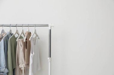 Beyaz duvarın yanında giysilerle dizilin. Metin için boşluk