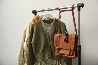 Giysileri ve çantaları ışık duvarının yanına dizin.