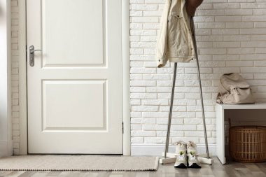 Koridorda ceketli ve spor ayakkabılı metal askılar.