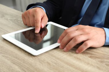 İşadamı ahşap masada tablet kullanıyor, yakın plan. Modern teknoloji
