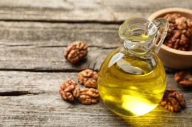 Sürahide yağ, ahşap masada ceviz, yakın plan. Metin için boşluk