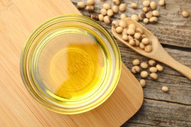 Tabakta yemek yağı, kaşık ve soya fasulyesi ahşap masada, düz uzanmış