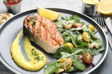 Sos ve salatalı ızgara somon bifteği, yakın plan.