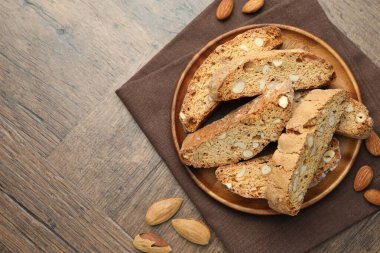 Geleneksel İtalyan badem bisküvileri (Cantucci) ve ahşap masada fındıklar, üst manzara. Metin için boşluk