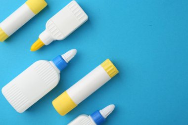 Açık mavi arkaplanda farklı tipte yapıştırıcı, düz. Metin için boşluk