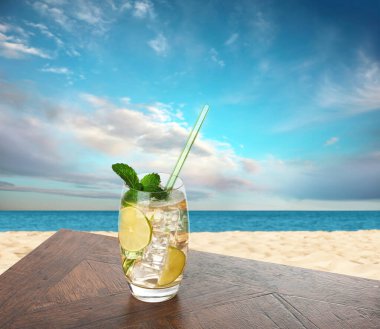 Plajdaki ahşap masada samanla taze içecek.