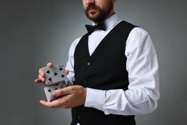 Gri arkaplanda profesyonel krupiye karıştırma kartları