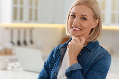 Mutlu orta yaşlı kadın portresi evde, mesaj için yer var.