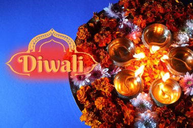 Mutlu Diwali tebrik kartları, Hindu ışık festivali. Diya lambaları ve mavi arka planda güzel çiçekler, üst manzara