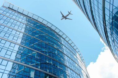 Şehirdeki binaların üzerinden uçan uçak, alçak açı.