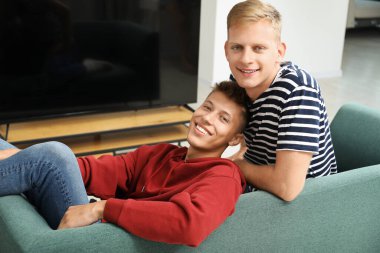 Evdeki kanepede mutlu kardeşlerin aile portresi.