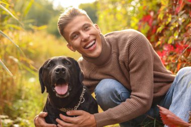 Gülümseyen adam ve sevimli köpek sonbahar günü açık havada