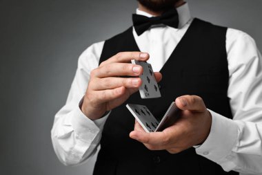 Gri arkaplanda profesyonel krupiye karıştırma kartları