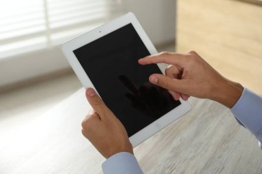 İşadamı ahşap masada tablet kullanıyor, yakın plan. Modern teknoloji