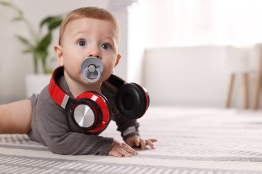 Evde emziği ve kulaklığı olan şirin bir bebek.