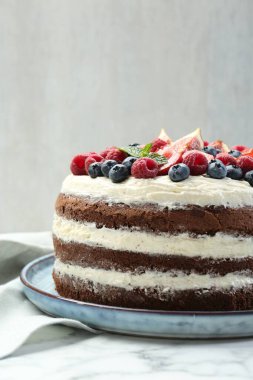 Lezzetli çikolatalı kek, beyaz masada böğürtlenli, yakından.
